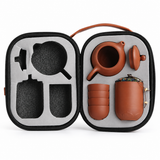 Portable Yixing Zisha clay tea set organized inside a protective travel case with teapot, cups, and tea caddy