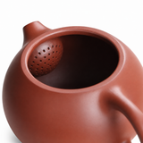 Close-up of Yixing Zisha clay teapot interior with built-in ball filter strainer