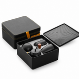 Portable black tea set with case open to show teapot, cups, and tray insert