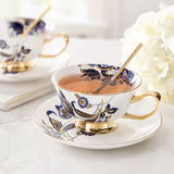 Blue and gold floral bone china cup filled with tea and matching saucer