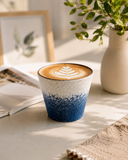 Ocean glaze ceramic latte cup on a table beside an open book and vase