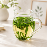 Glass pitcher of steeped LuAn GuaPian green tea with fresh leaves