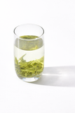 Fresh brewed Maojian green tea in glass cup showing light green tea liquor and tender tea leaves, premium Chinese organic green tea