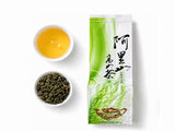 Loose leaf Alishan aromatic oolong tea with brewed golden liquor and tea leaves beside the package