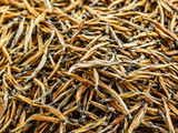 Close-up of loose golden Yunnan Dianhong tea buds