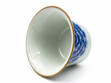 Celadon porcelain gaiwan lid with blue floral motif and golden-brown rim