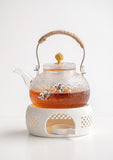 Japanese glass teapot with warming base and candle heater on white background