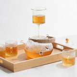 Japanese glass teapot and cups on bamboo tray with warming stand and tea filter cup
