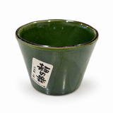 Japanese green glaze noodle dipping cup with a dark rim, tapered sides, and original Japanese label, front view