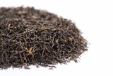 Premium Keemun loose leaf black tea from Anhui China with dark twisted leaves and golden buds.