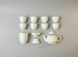 Set of white ceramic tea cups and teapot in a box