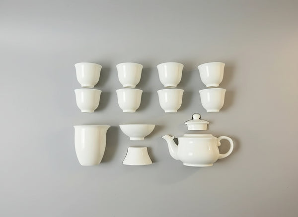 Set of white ceramic tea cups and teapot in a box